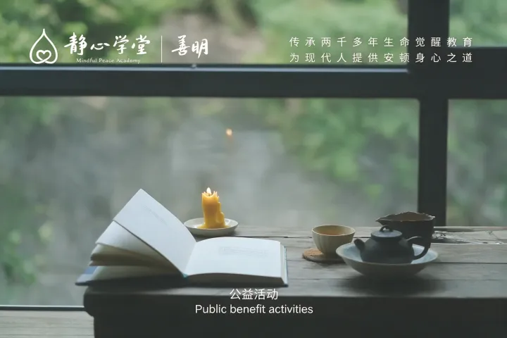 静坐书桌上打开的书籍、点燃的蜡烛和茶杯,背景为绿色户外景观